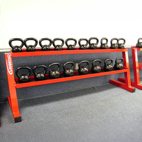 Set of black kettlebells on a red metal stand in a gym setting