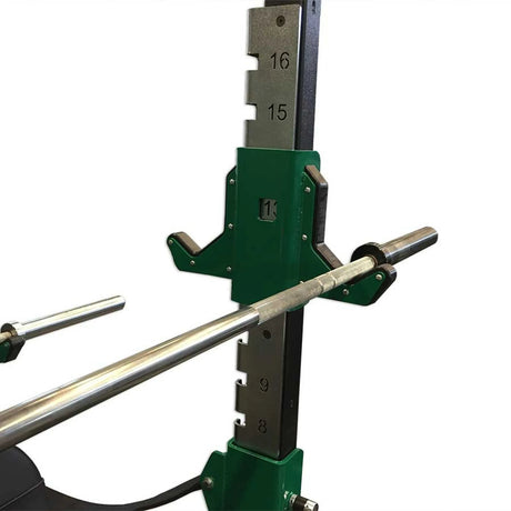 Green and black double-sided barbell hooks with a barbell stowed on one side mounted on a vertical metal upright