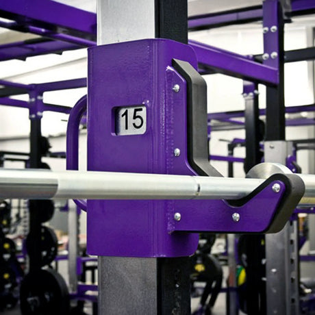 Purple barbell hook with a barbell stored on it in a gym setting