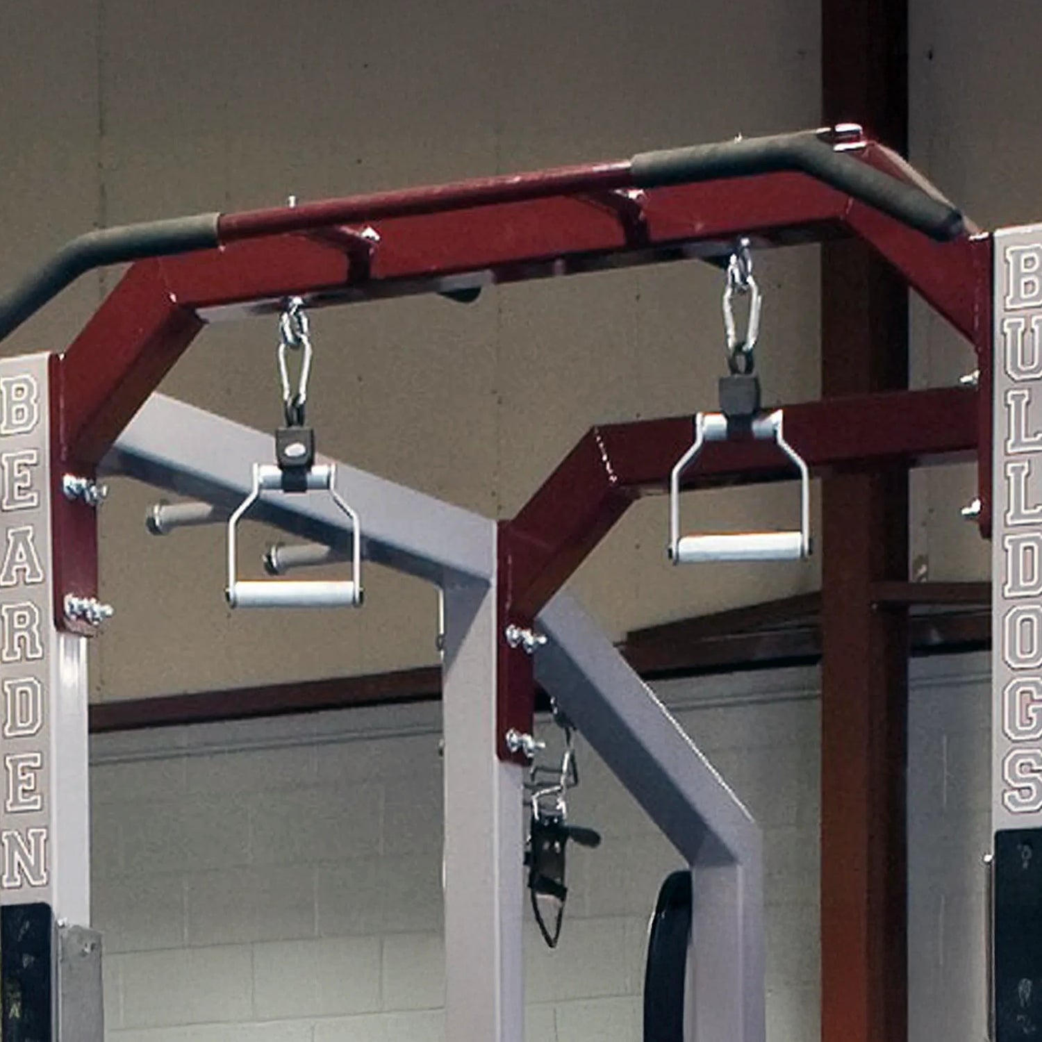 Metal pull-up handles hanging from a squat rack pull-up bar
