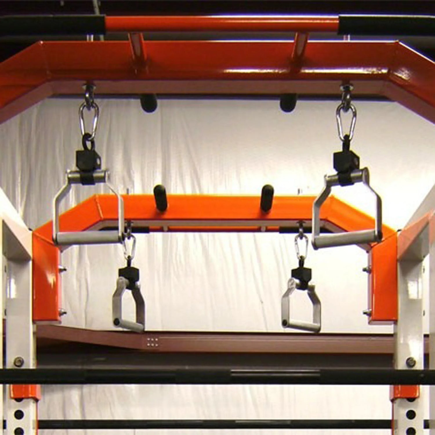 Metal pull-up handles hanging from a squat rack pull-up bar