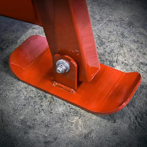 Close-up of a red metal stand with a bolt on a gray concrete floor