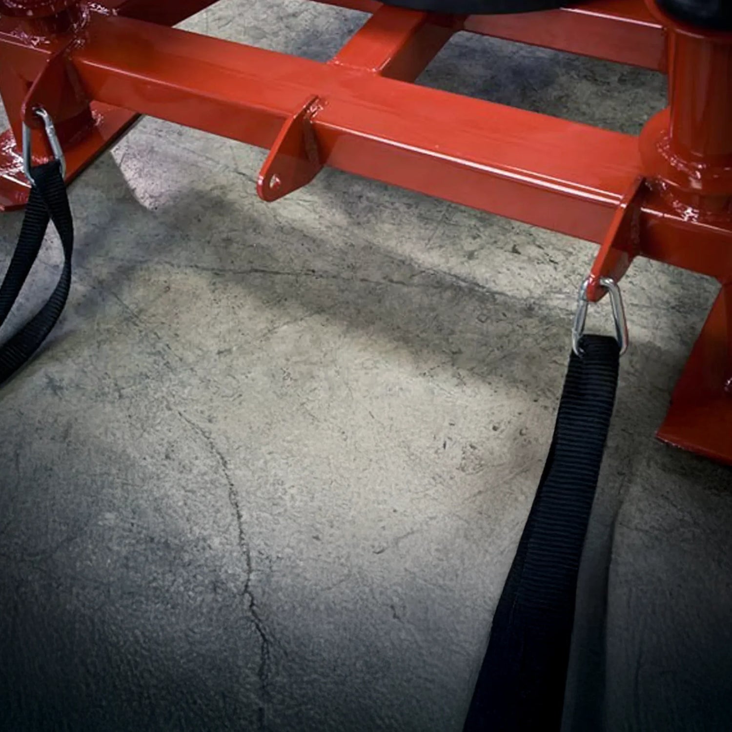 Red metal frame with straps on a concrete floor