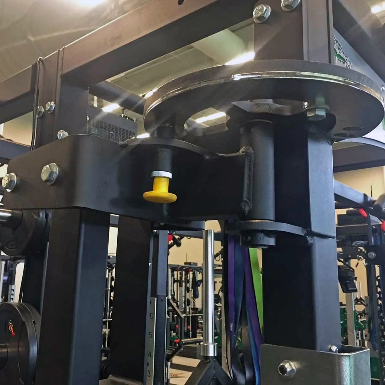 A closeup image of the top portion of rotating jammer arms connected to a Legend Fitness weight lifting cage