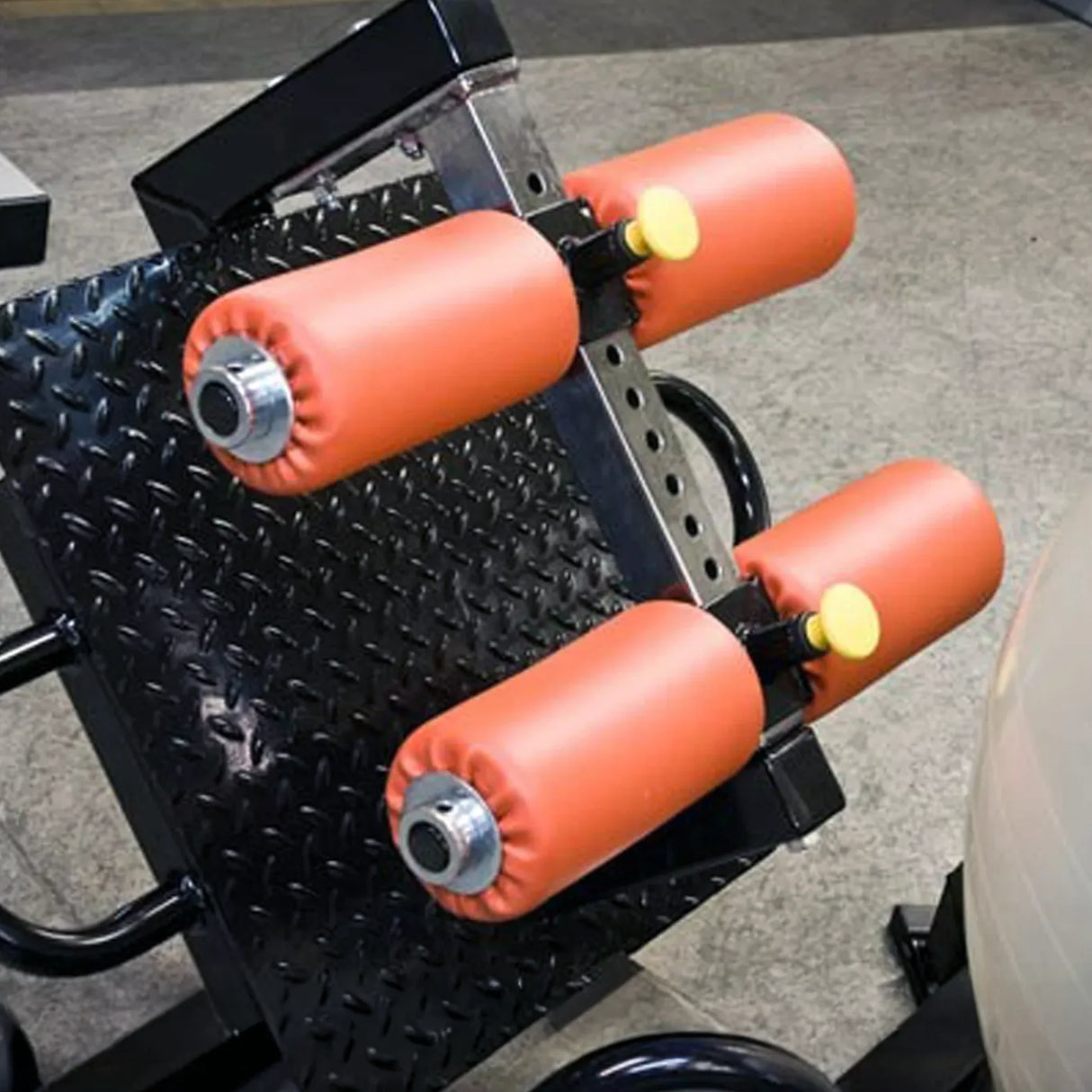 Gym equipment with orange padding on a gray floor