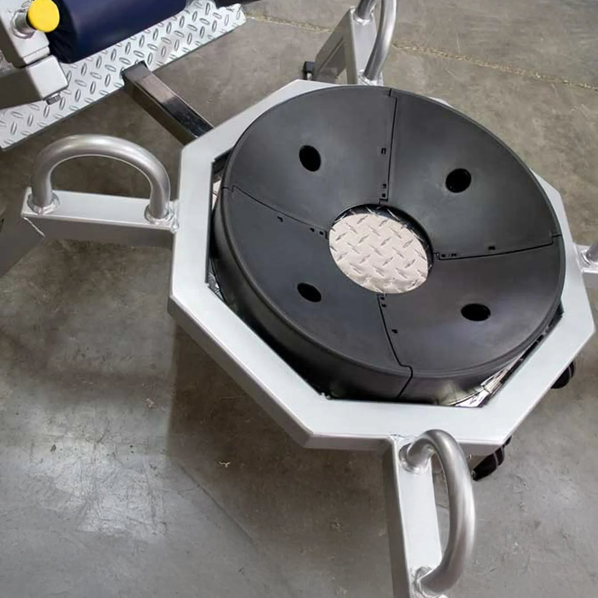 A gray metal frame from a piece of fitness equipment on a concrete floor