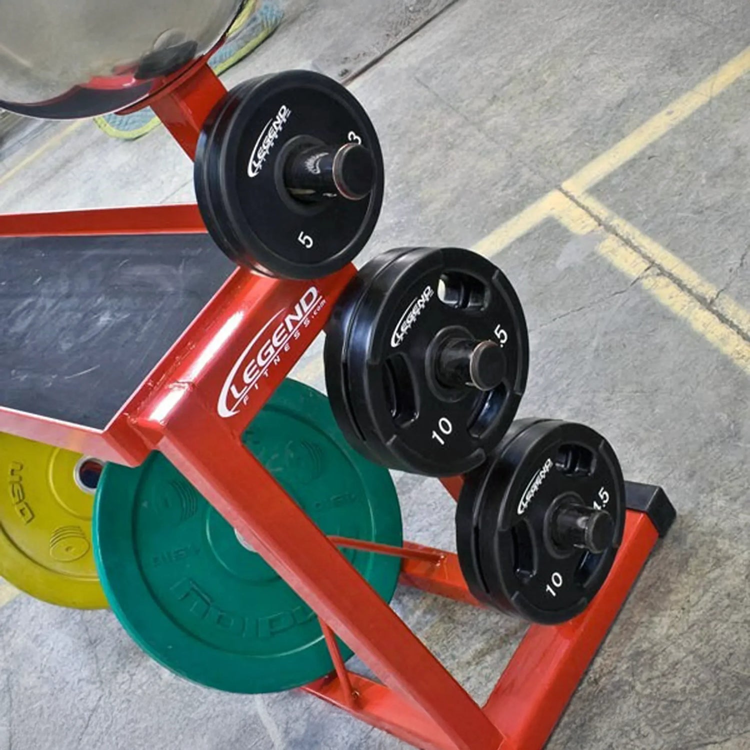 A red weightlifting storage rack with black, green and yellow plates