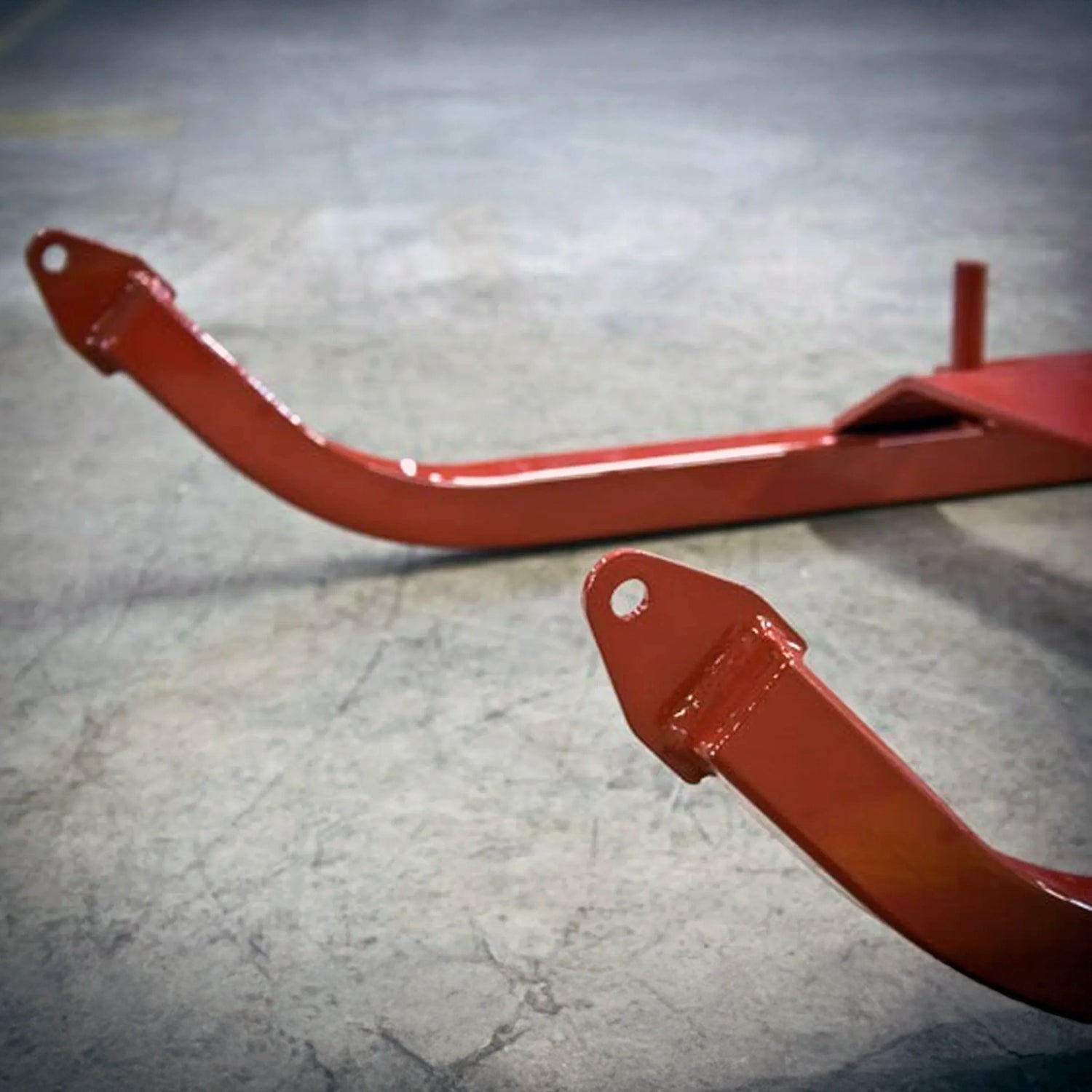 Red metal bracket on a gray concrete floor