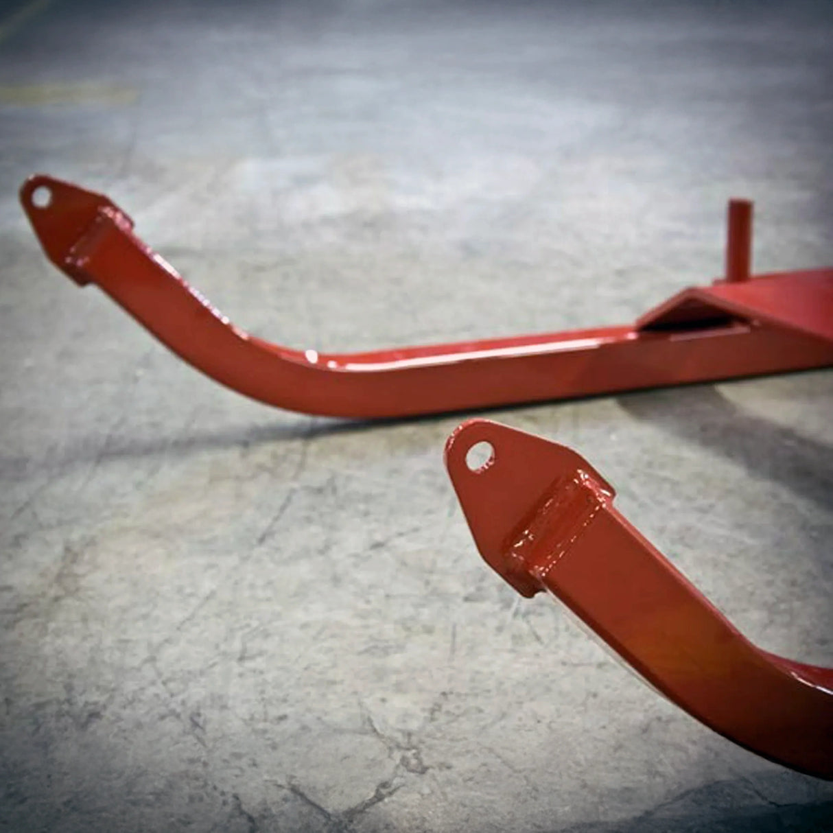 Red metal bracket on a gray concrete floor