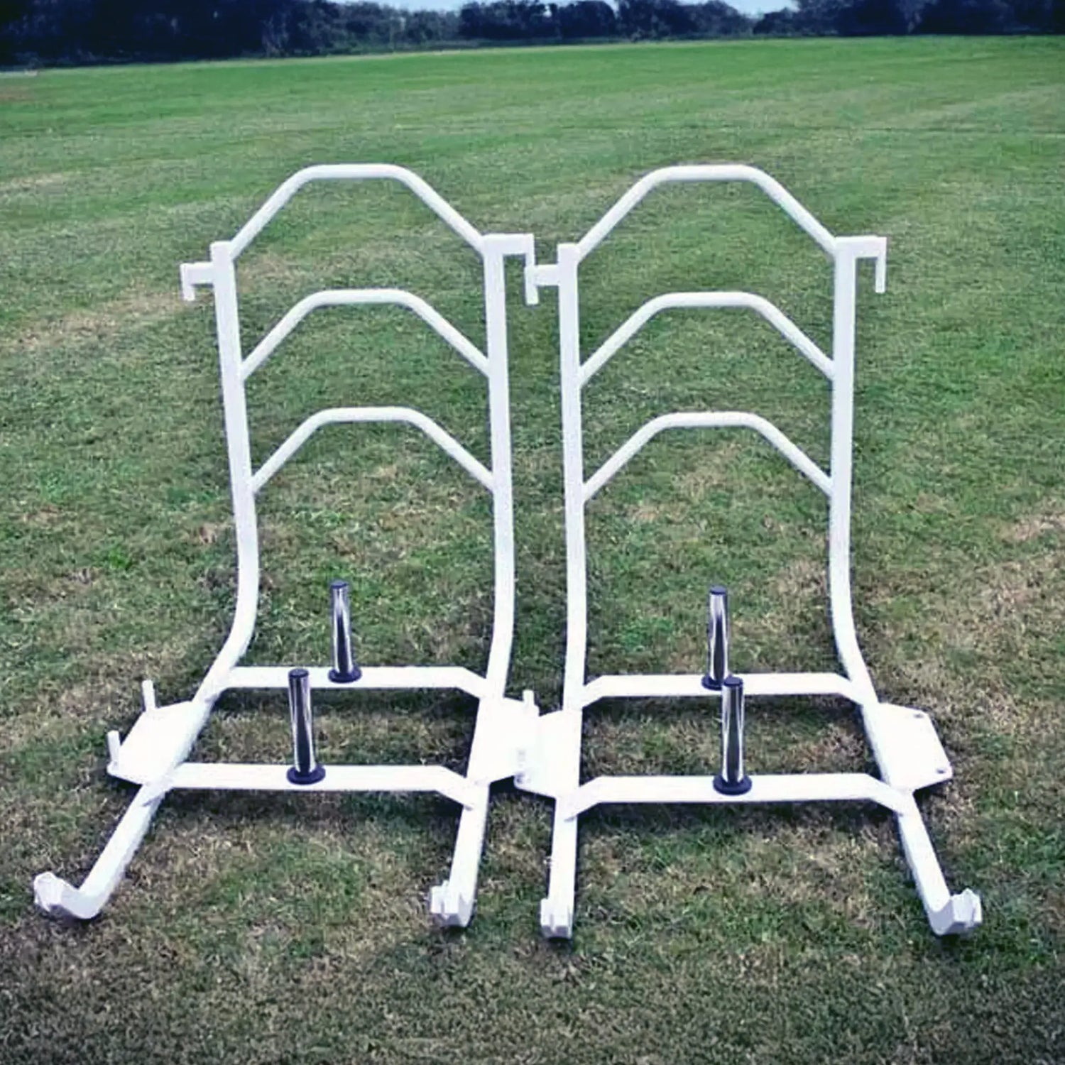 Two white metal push sleds on grass