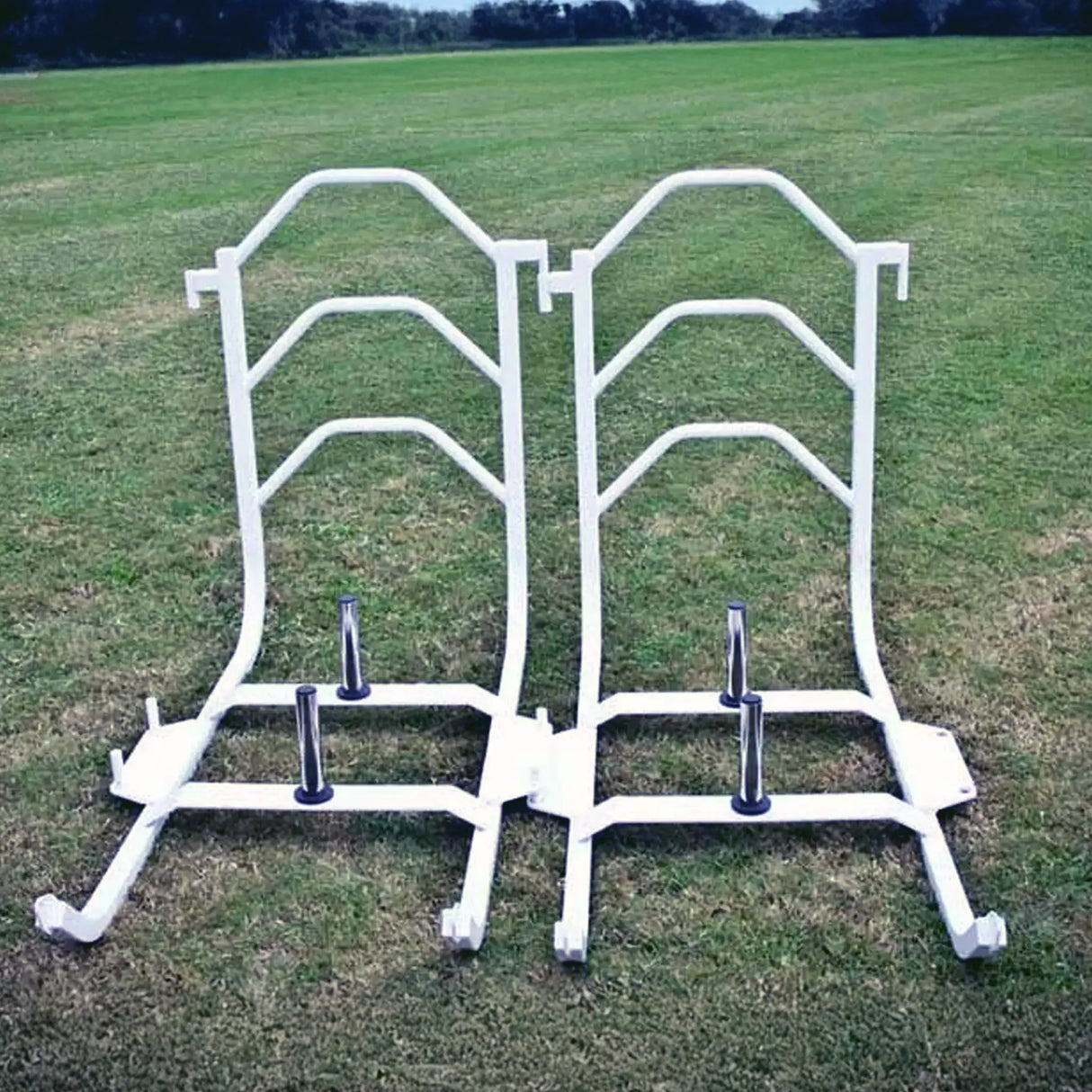 Two white metal push sleds on grass