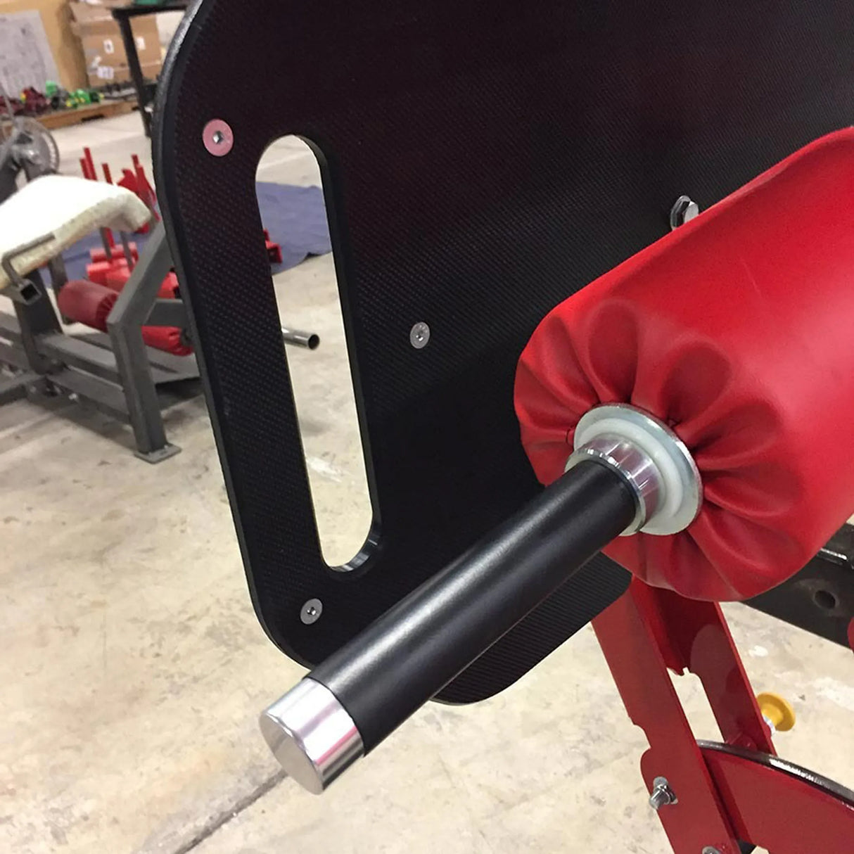 Red foam roller pad on a fitness machine in a gym setting