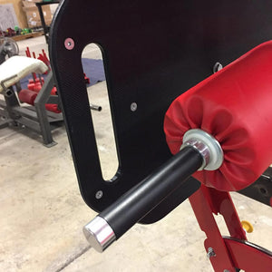 Red foam roller pad on a fitness machine in a gym setting
