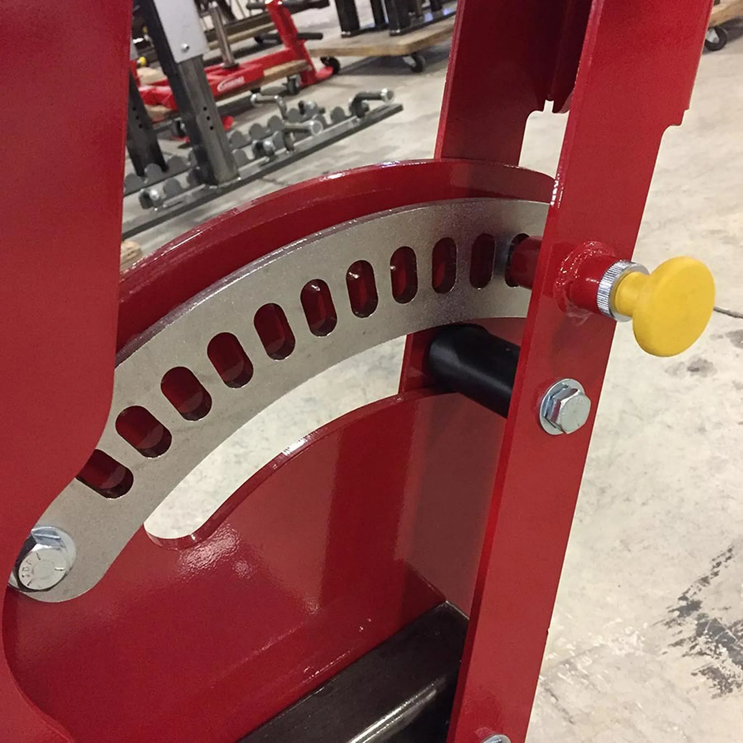 Red mechanical device with a yellow knob in an industrial setting