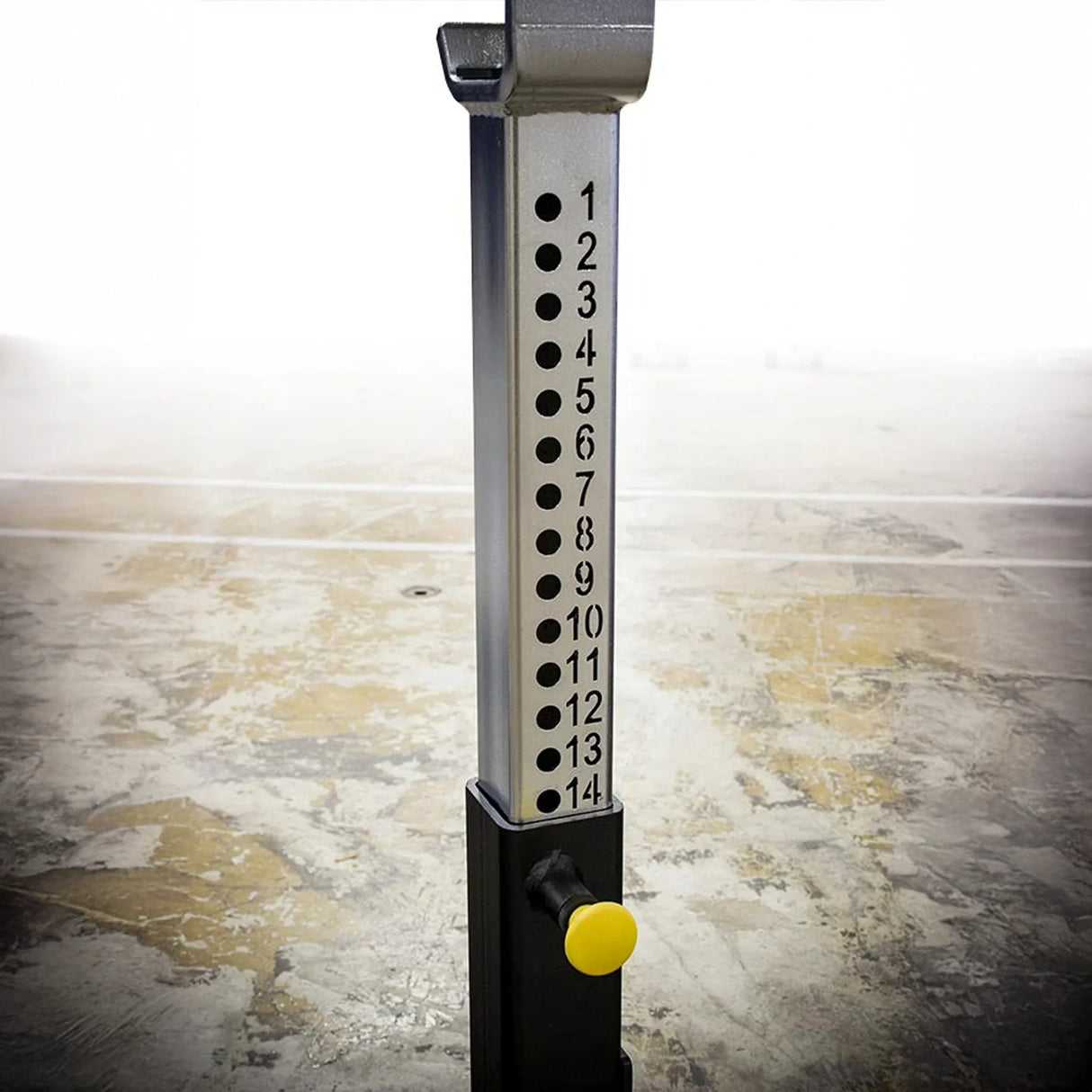 Silver and black barbell stand with numbers 1 through 14 and a yellow pop pin