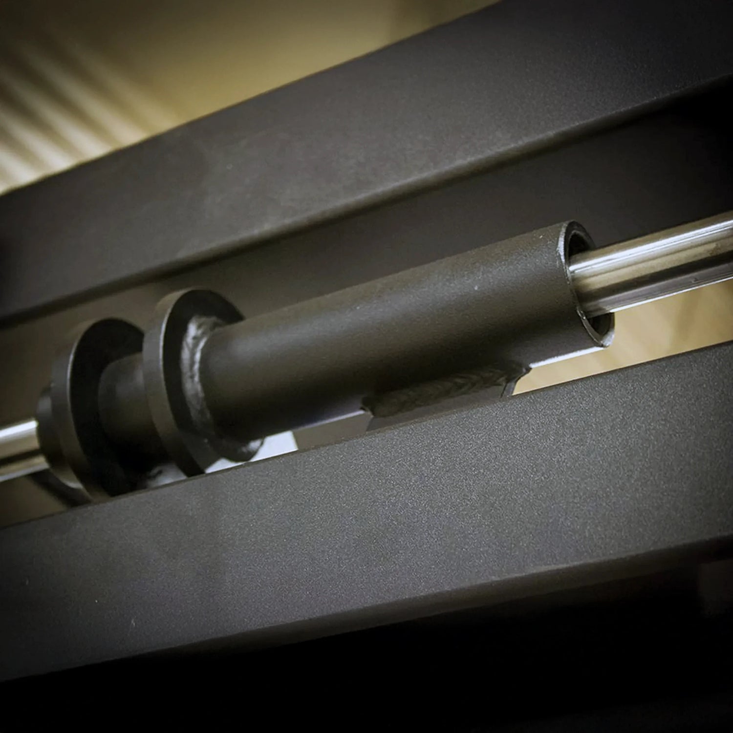 Close-up of a mechanical component with metal rods and black metal bushings.