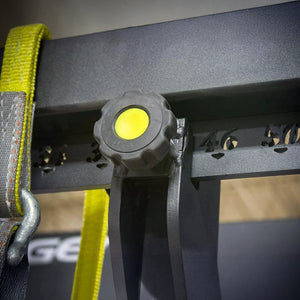 Close-up of a black and yellow turn knob on a weightlifting monolift