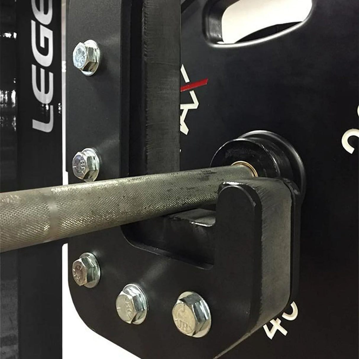 Close-up of a weightlifting bar attached to a squat rack with visible branding.