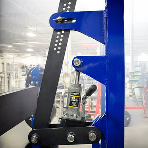 Close-up of a blue gym machine with a hydraulic press attached