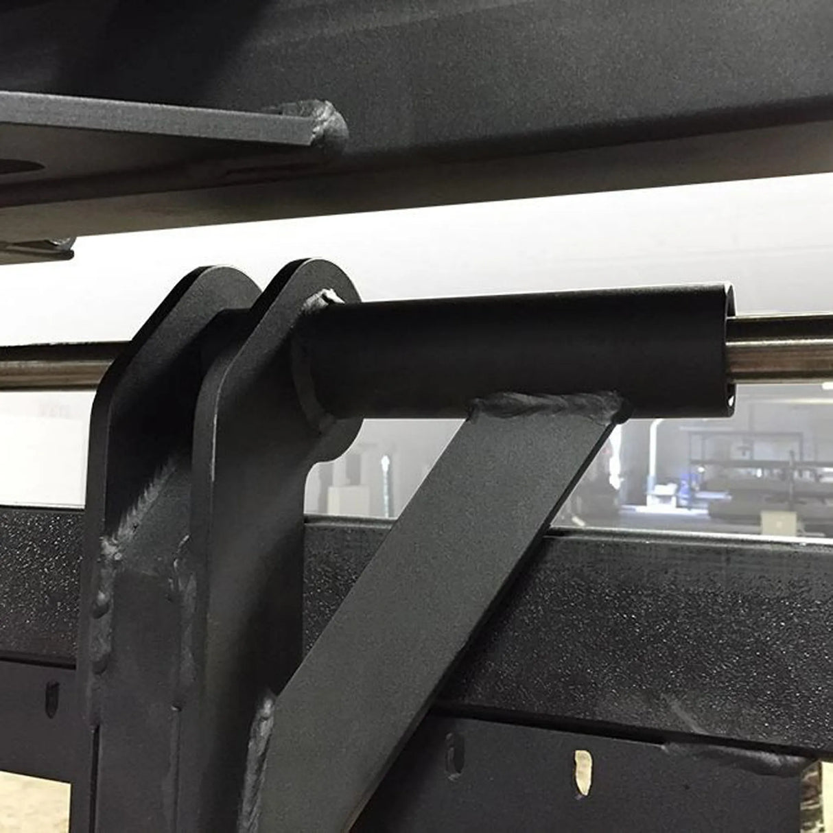 Closeup of some black metal components on a weightlifting machine