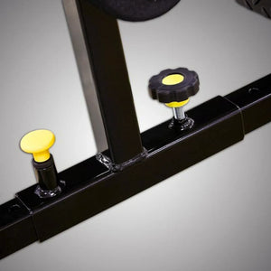Close-up of a black metal frame with yellow knobs on a gray background