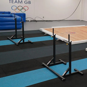 Two pairs of black squat stands in a gymnastics facility