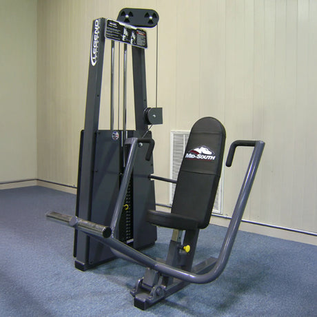 The Legend Fitness 900 Chest Press Machine by Legend Fitness features black padding, a gray metal frame, and adjustable weights and handlebars for strength training. It is placed on blue carpet in a room with beige walls.