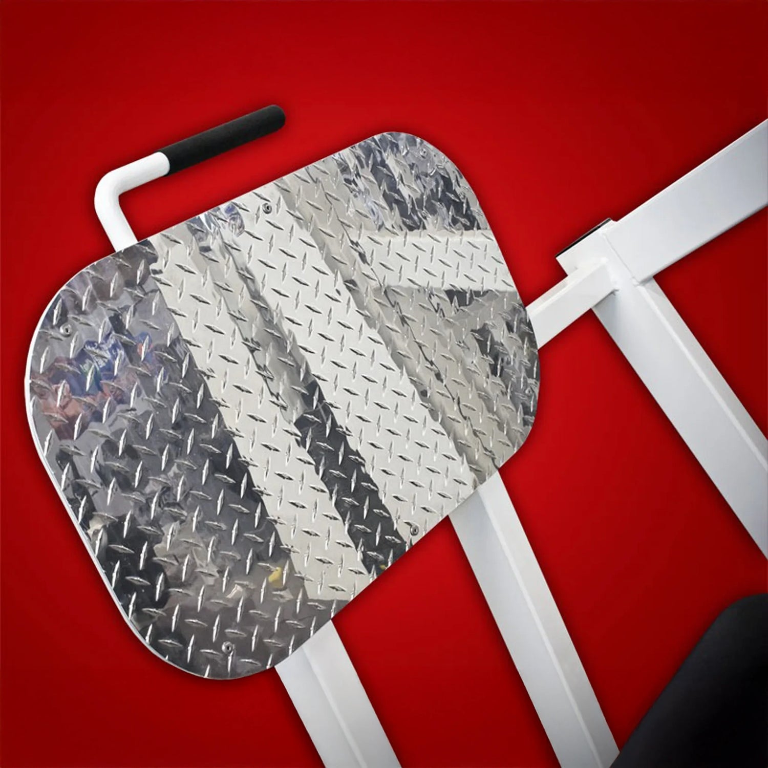 A close-up of the metal diamond plate footrest on the Legend Fitness 914 Supine Leg Press Machine by Legend Fitness, positioned against a solid red background.