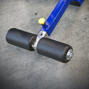 Close-up of the Legend Fitness 941 Ab Crunch Machine by Legend Fitness, featuring two black padded rollers and a yellow adjustment knob, on a textured gray floor.