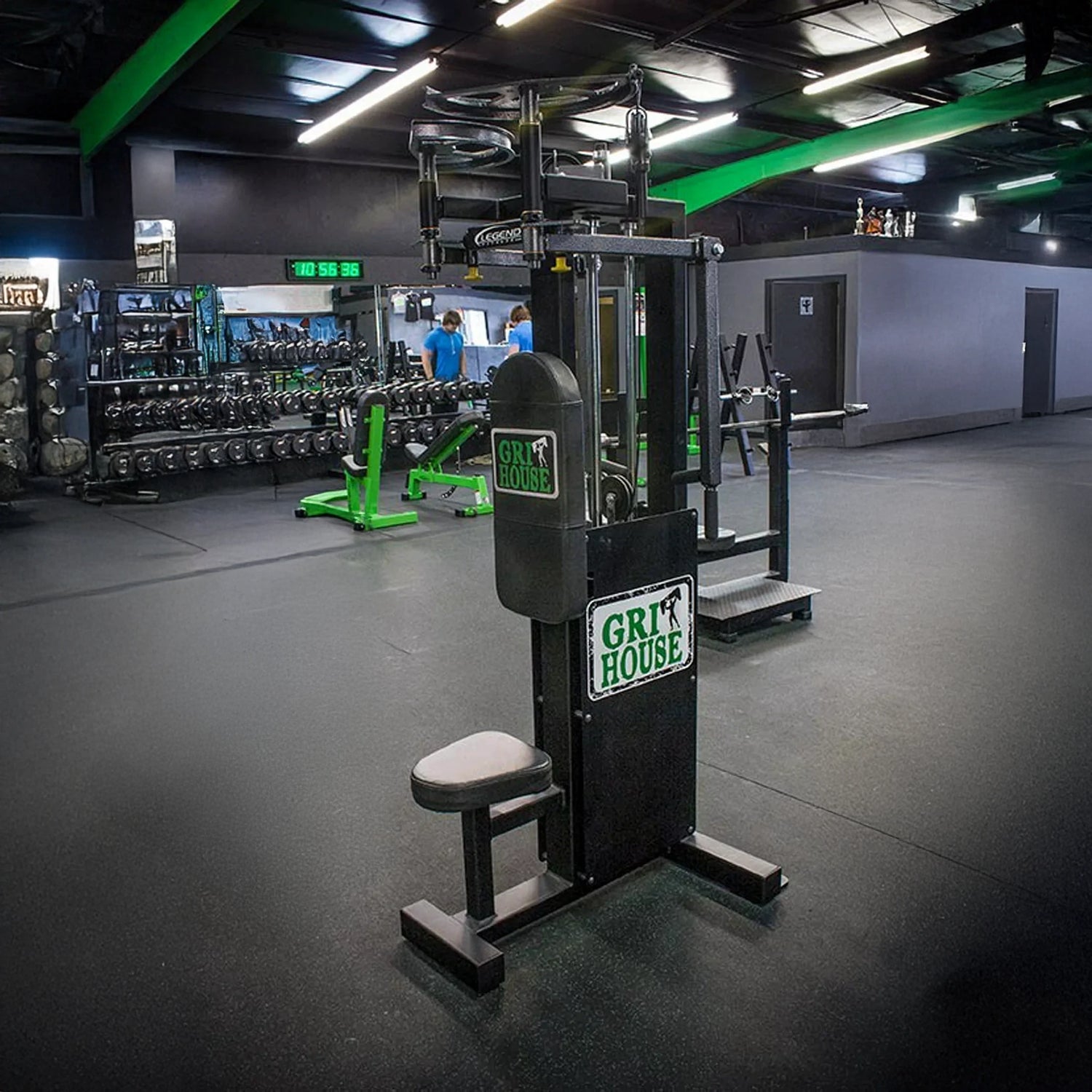 A Legend Fitness 942 Rear Delt / Pec Combo Machine stands in a spacious gym with black flooring, green accents, mirrors, free weights, and other workout equipment visible in the background.