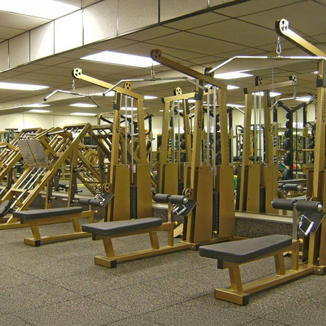 A gym featuring the Legend Fitness 945 Lat Pull / Low Row Combo Machine by Legend Fitness, with mirrored walls and a carpeted floor for a spacious and organized workout area.