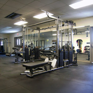A clean, modern gym featuring the Legend Fitness 965 Combo Jungle Machine by Legend Fitness, benches, wall mirrors, and neatly organized gym equipment in a spacious, well-lit room with a black rubber floor.
