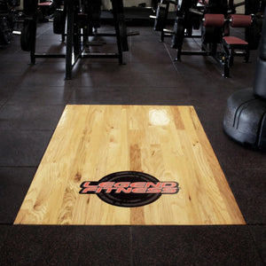 Wooden floor platform surrounded by rubber tiles and gym equipment with a Legend Fitness logo on the wooden portion
