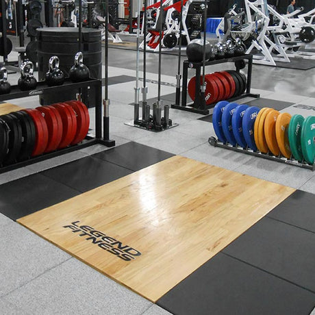 Gym interior with a wooden platform branded with 'Legend Fitness'