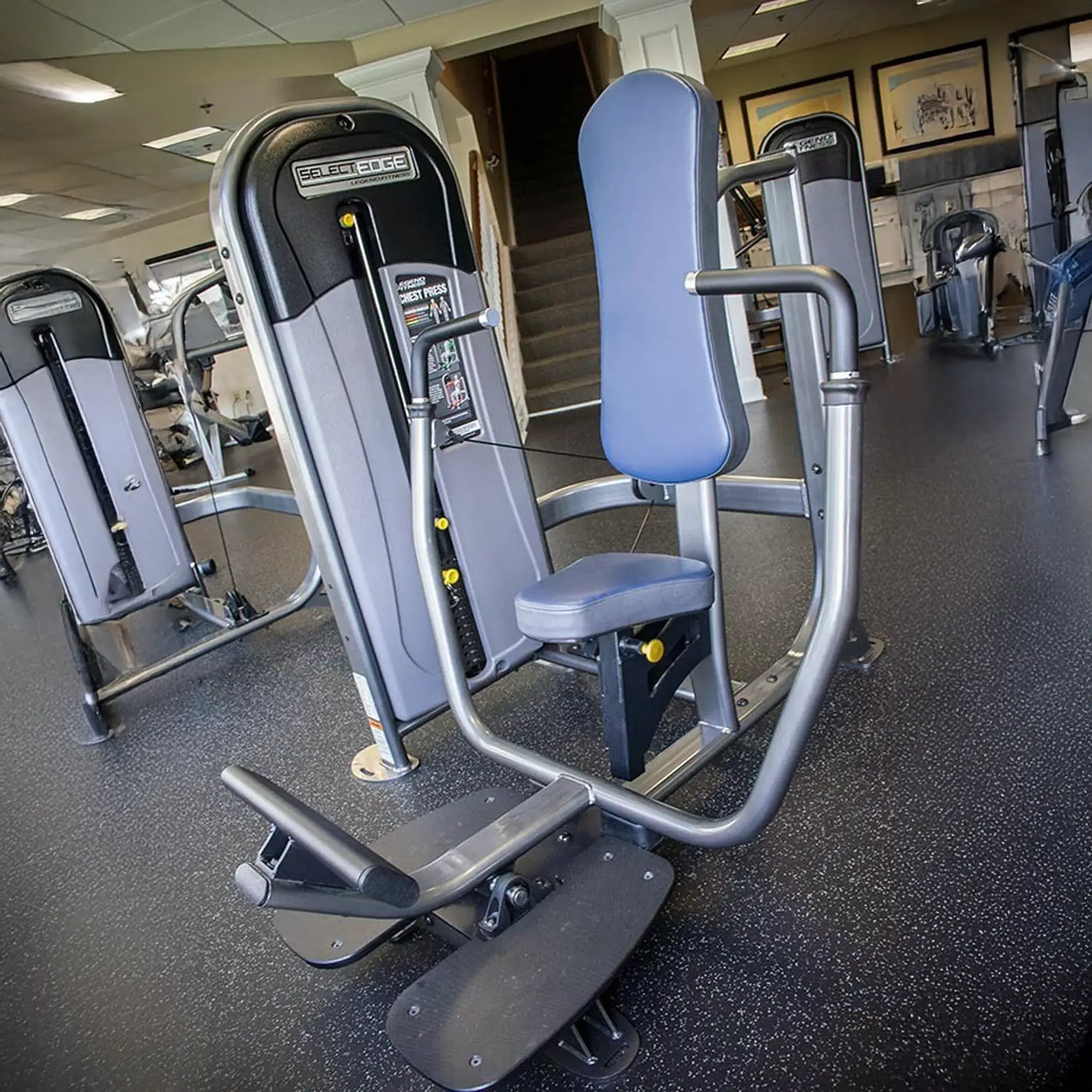 Gym machine in a fitness center with other equipment in the background
