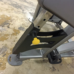 Close-up of a mechanical component with a yellow pop-pin on a concrete floor.