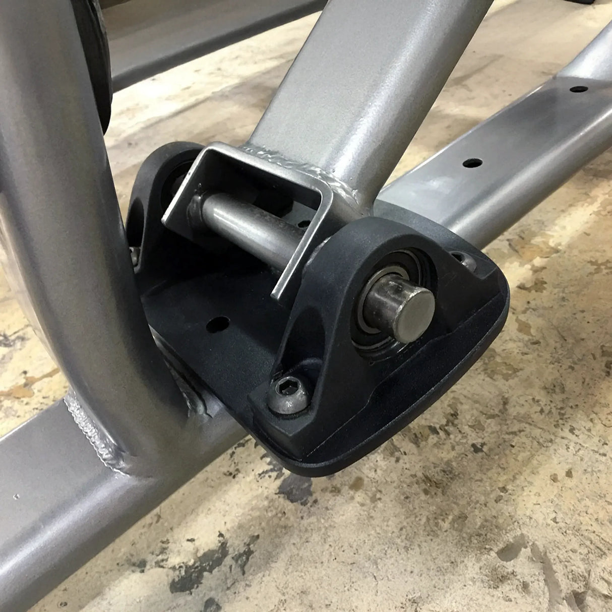 Metal frame with a black mounting bracket on a concrete floor