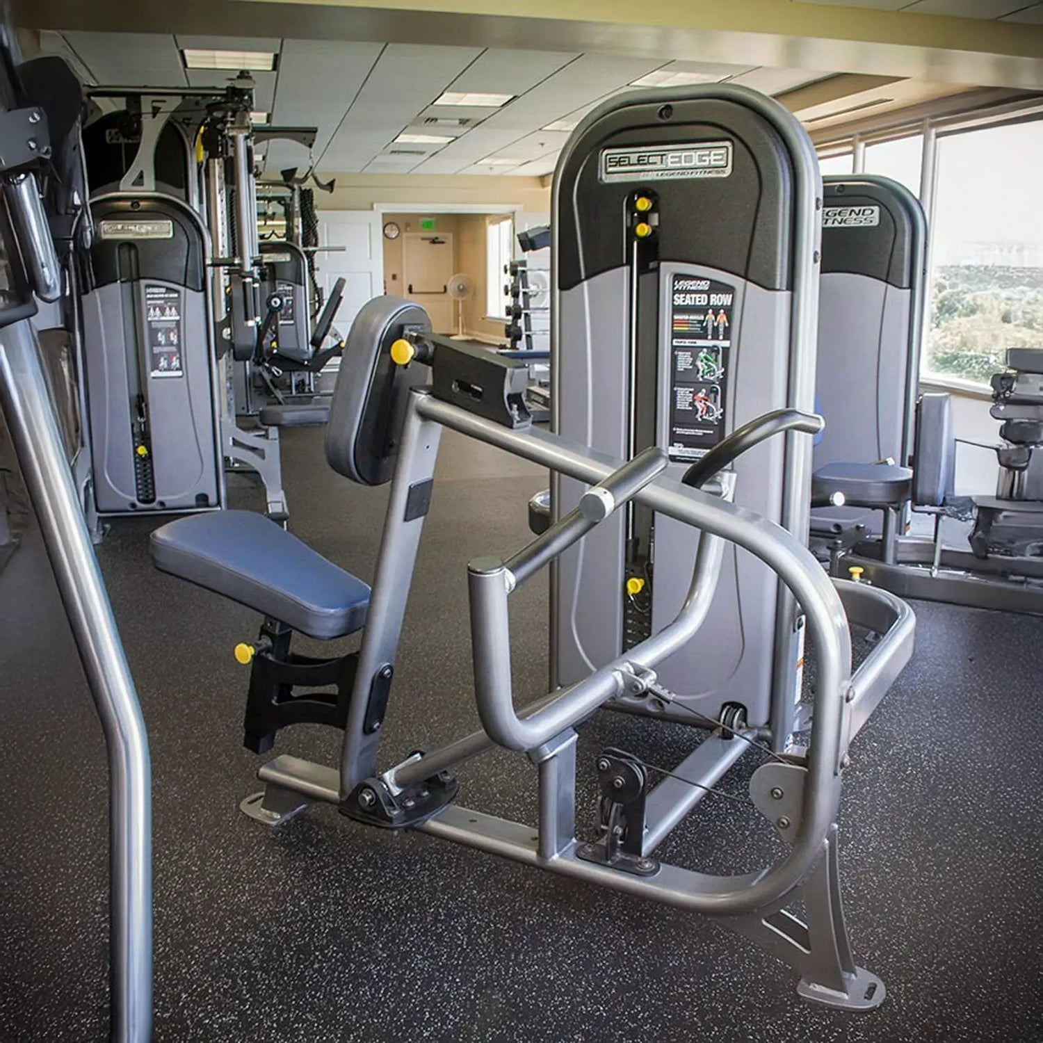 Gym machine in a fitness center with windows showing outdoor view