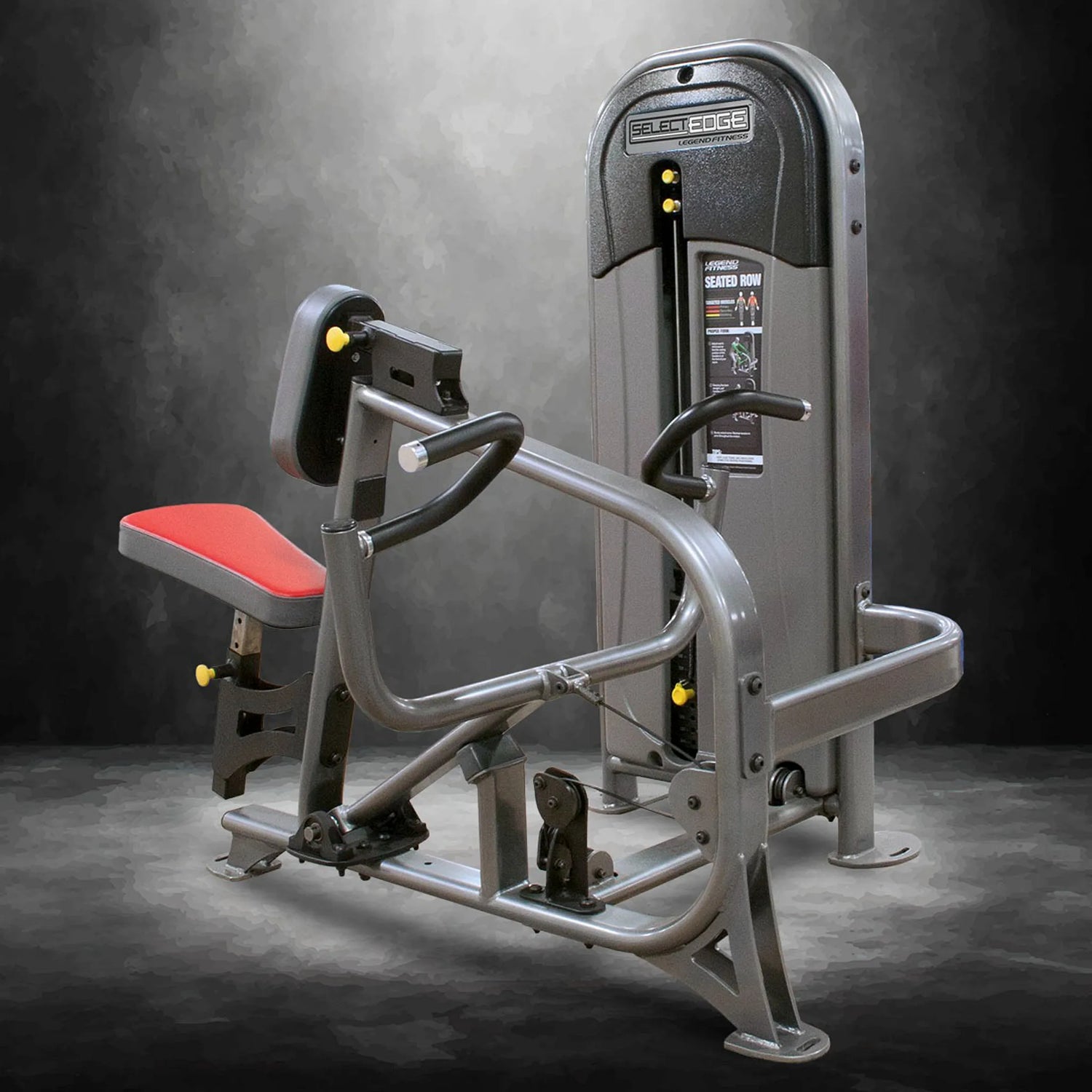 Gym machine with red seat and gray frame on a dark background