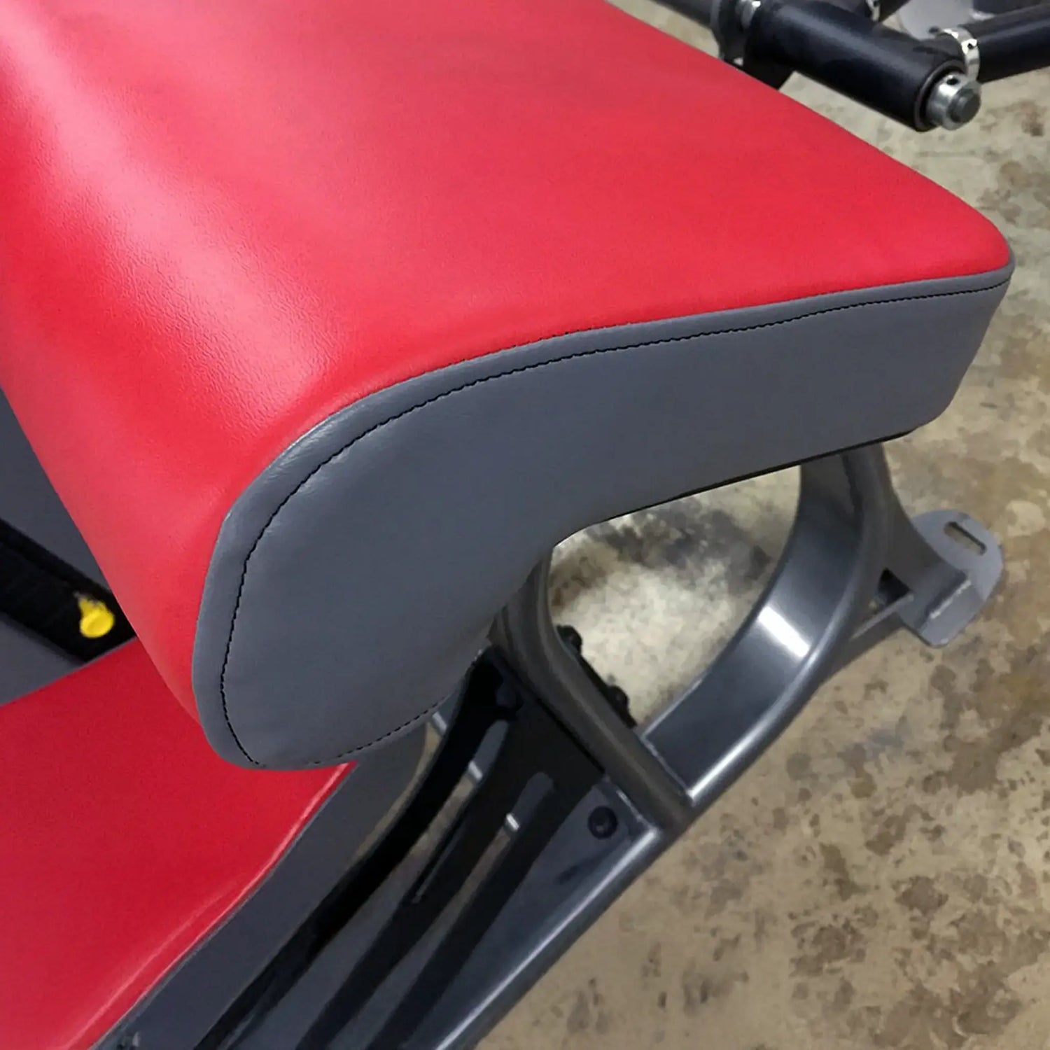 Red and gray exercise bench on a concrete floor