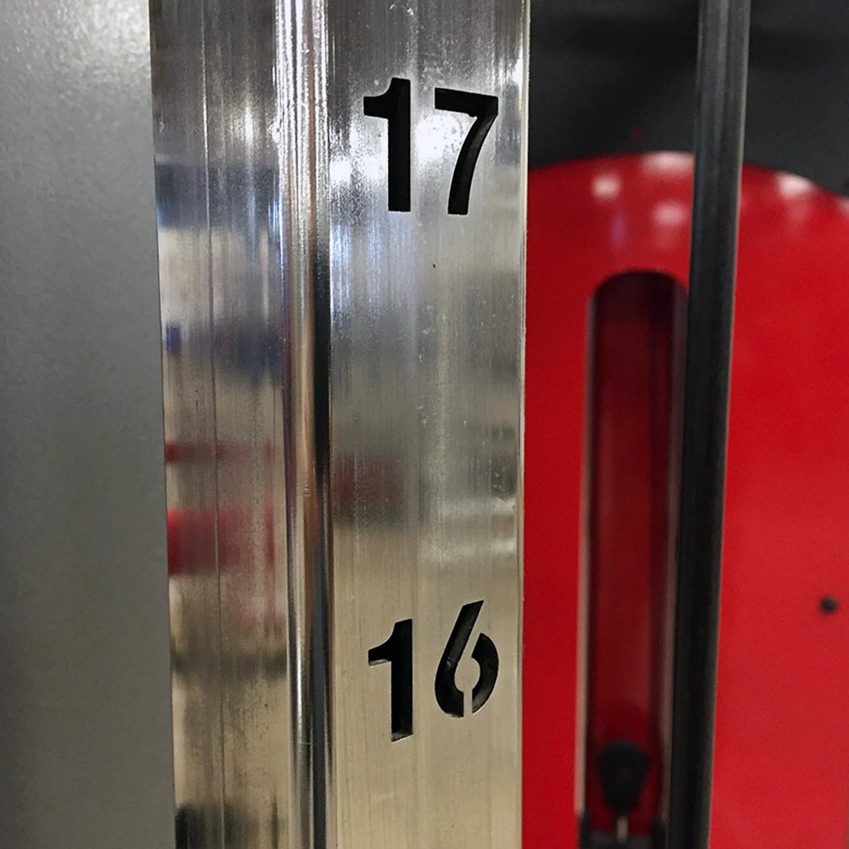 Closeup image of a vertical metal beam with the numbers 17 and 16 cut into the side of the beam