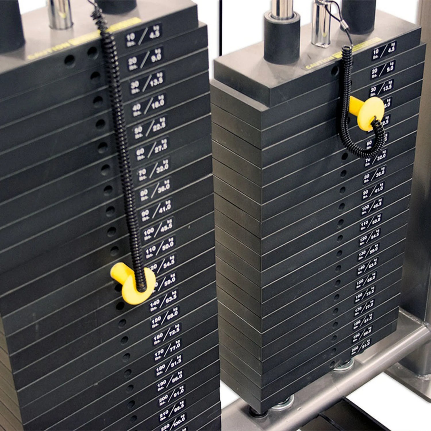 Two side-by-side black weight stacks on a piece of gym equipment