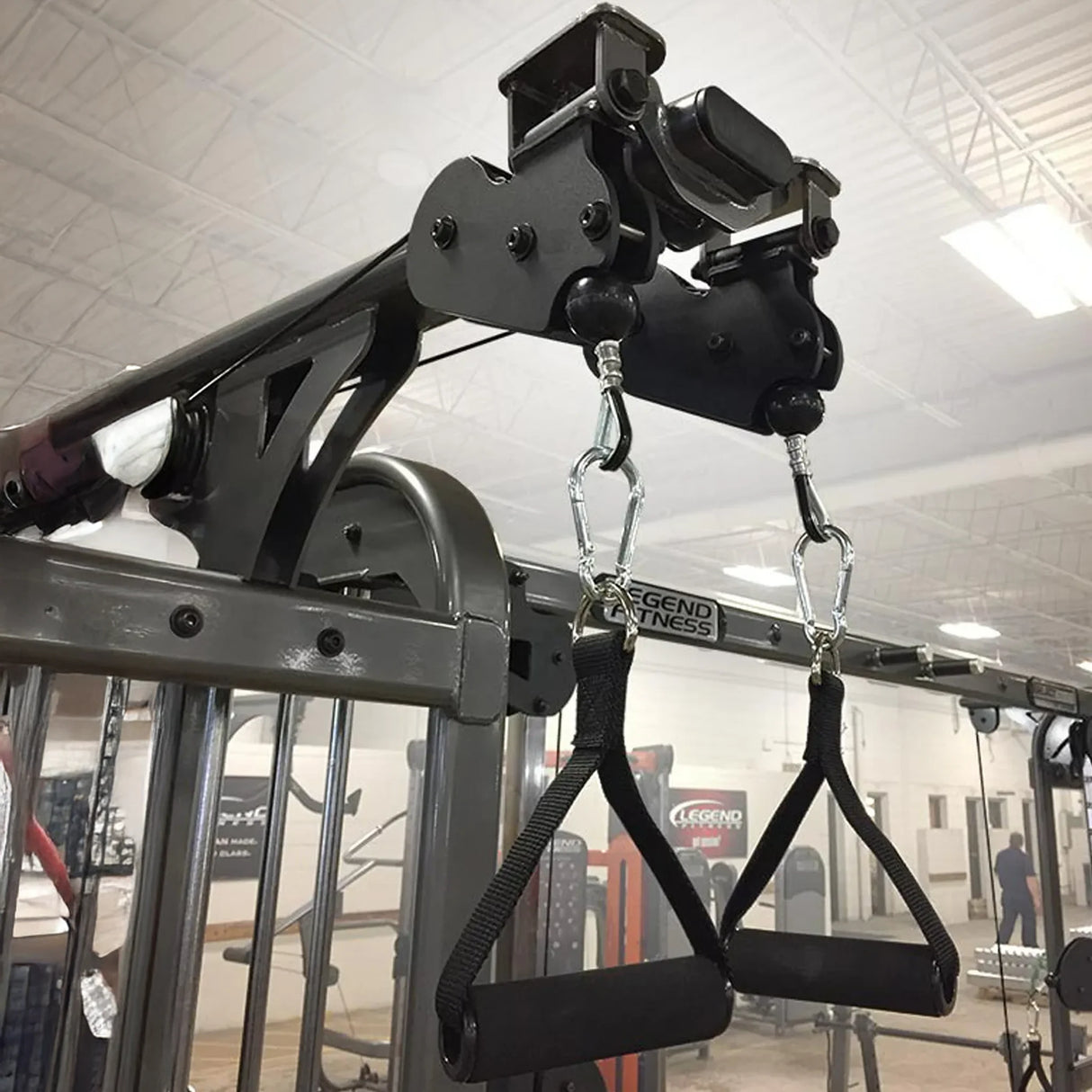 Two black nylon D grip handles hanging from a piece of gym equipment