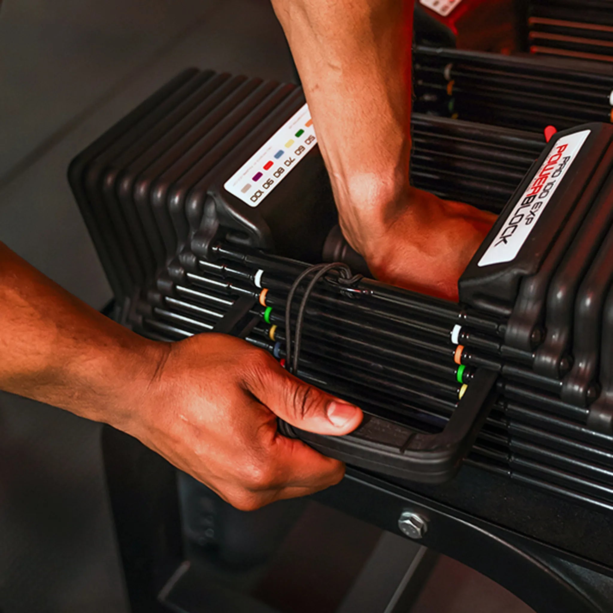 A man adjusting the selector pin on a PowerBlock Pro 100 Expandable Dumbbell