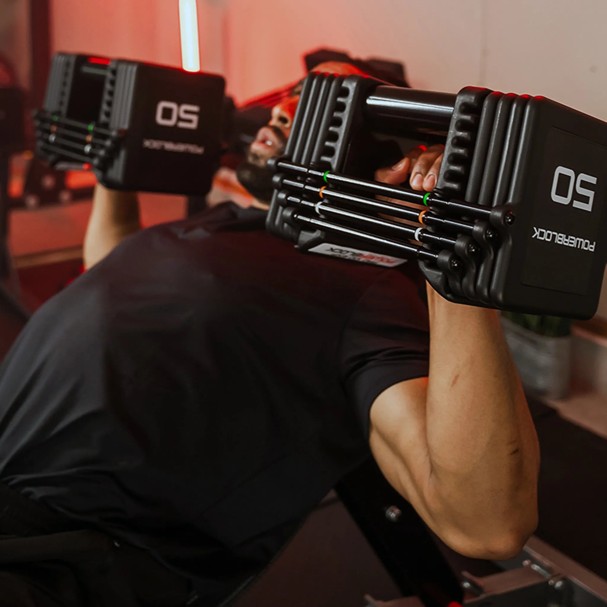 A man incline chest pressing a pair of PowerBlock Pro 100 Expandable Dumbbells