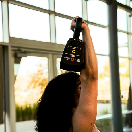 A PowerBlock Commercial Standard Adjustable Kettlebell with four weight options which include 18lb, 22lb, 26lb, and 35lb