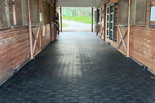 Brick stables with black rubber pavers on the floor