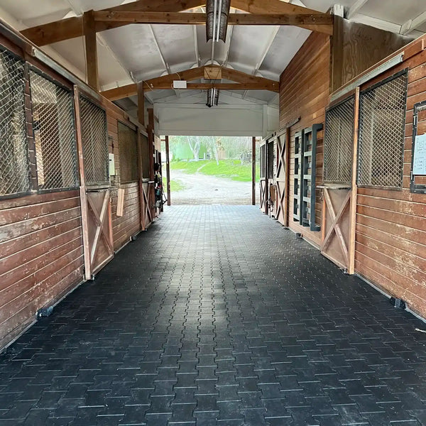 Brick stables with black rubber pavers on the floor