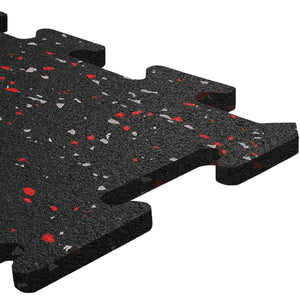 A close-up of ECORE Athletic's ECORE Rubber Floor Tiles - 8mm Interlocking, black with red and gray speckles, showcases the textured surface and puzzle-like edges for easy assembly.