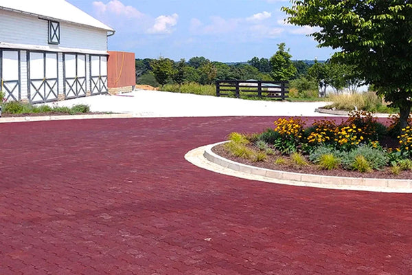 Red rubber paver turnaround with a large garage in the background